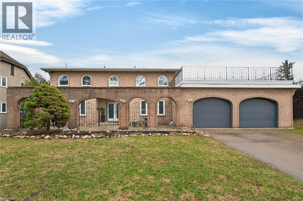 View of front of house featuring driveway, an attached garage, brick siding, and a front yard - 22 Woodside Drive, Hamilton, ON - Outdoor