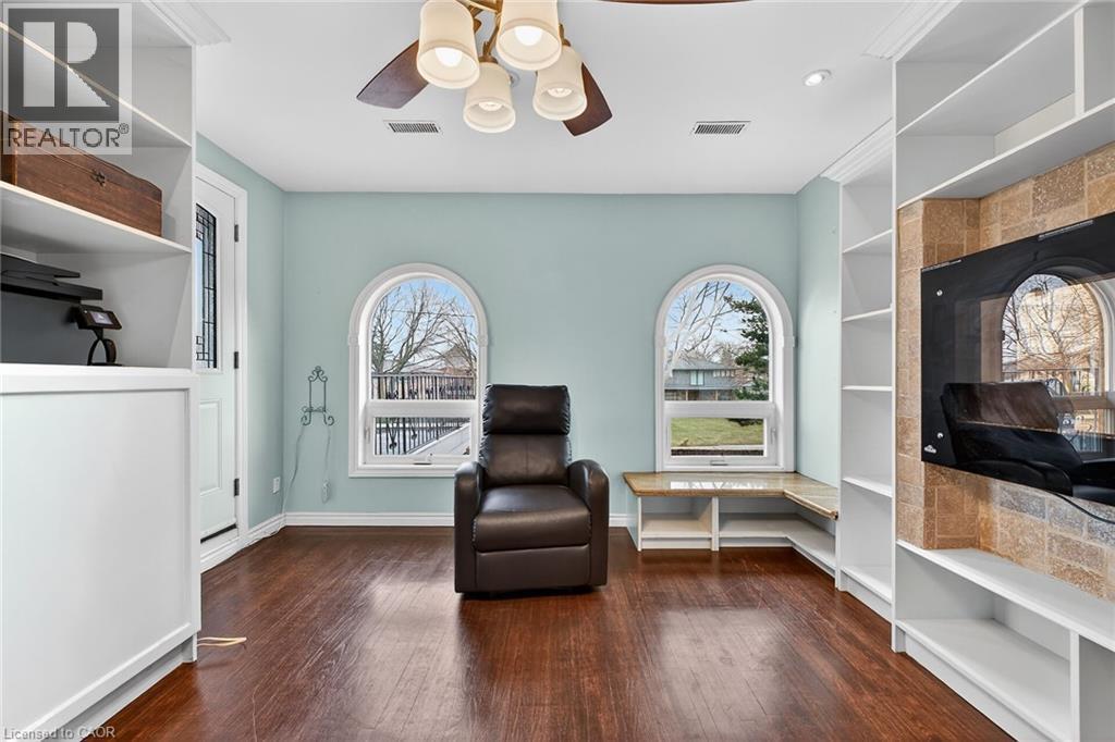 Sitting room with ceiling fan, healthy amount of natural light, dark wood-style floors, and built in features - 22 Woodside Drive, Hamilton, ON - Indoor