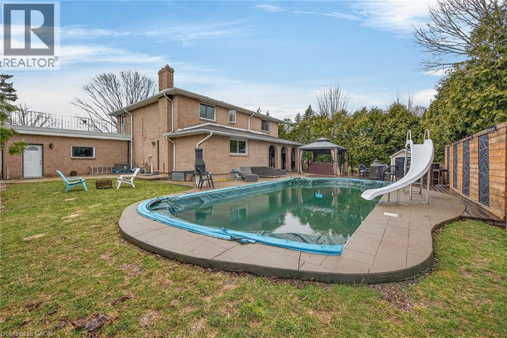 View of pool featuring a gazebo, a water slide, and patio surround - 22 Woodside Drive, Hamilton, ON - Outdoor With Backyard
