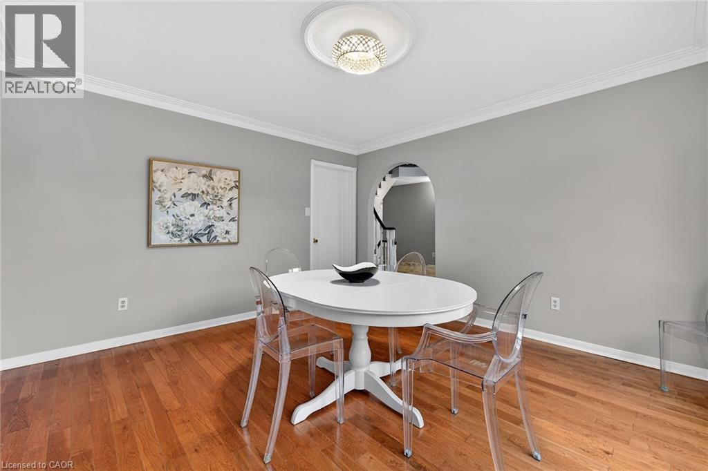 Dining area with ornamental molding, light wood-type flooring, and arched walkways - 22 Woodside Drive, Hamilton, ON - Indoor Photo Showing Dining Room