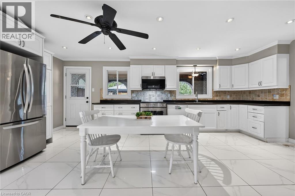 Kitchen featuring stainless steel appliances, dark countertops, white cabinets, ceiling fan, and ornamental molding - 22 Woodside Drive, Hamilton, ON - Indoor Photo Showing Kitchen With Upgraded Kitchen