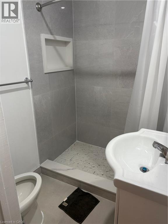 Full bath featuring a stall shower, vanity, and tile patterned flooring - 95 Sanford Avenue N, Hamilton, ON - Indoor Photo Showing Bathroom