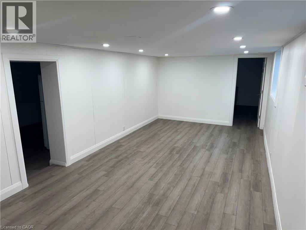 Finished below grade area with recessed lighting, light wood finished floors, and freestanding refrigerator - 18 Cyprus Drive Unit# Lower, Kitchener, ON - Indoor