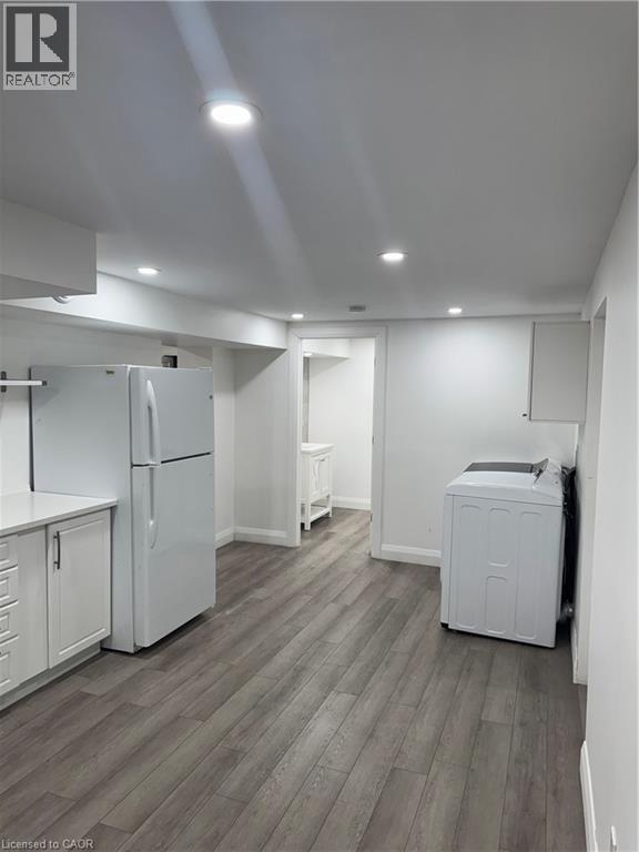 Laundry area featuring dark wood-style floors and recessed lighting - 18 Cyprus Drive Unit# Lower, Kitchener, ON - Indoor