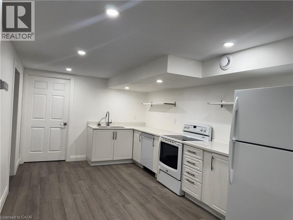 Kitchen featuring white appliances, dark wood-type flooring, white cabinetry, recessed lighting, and open shelves - 18 Cyprus Drive Unit# Lower, Kitchener, ON - Indoor Photo Showing Kitchen