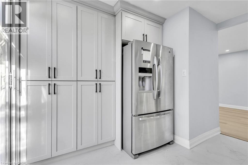 Kitchen with stainless steel refrigerator with ice dispenser, light marble finish floors, and recessed lighting - 84 Avalon Place, Kitchener, ON - Indoor