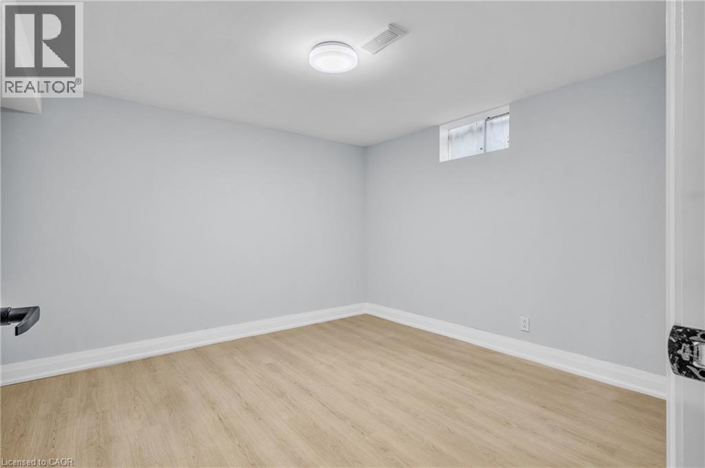 Below grade area with light wood-style floors and baseboards - 84 Avalon Place, Kitchener, ON - Indoor Photo Showing Other Room