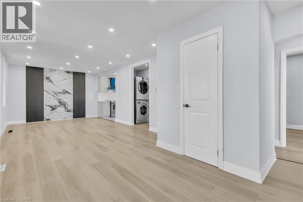 Unfurnished living room featuring recessed lighting, light wood-type flooring, and stacked washer / dryer - 84 Avalon Place, Kitchener, ON - Indoor Photo Showing Other Room