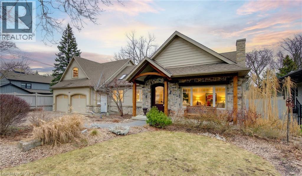 View of front of home with a chimney, stone siding, and covered porch - 140 Aberdeen Road, Kitchener, ON - Outdoor With Facade