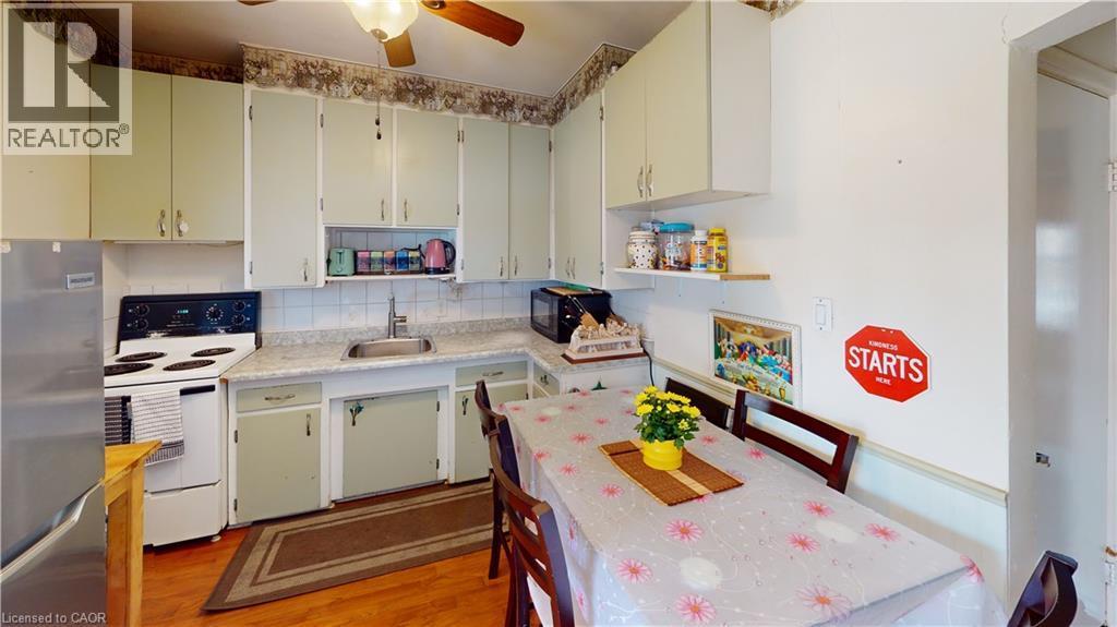 Kitchen featuring freestanding refrigerator, electric stove, open shelves, a ceiling fan, and decorative backsplash - 10 Armstrong Avenue, Hamilton, ON - Indoor Photo Showing Kitchen