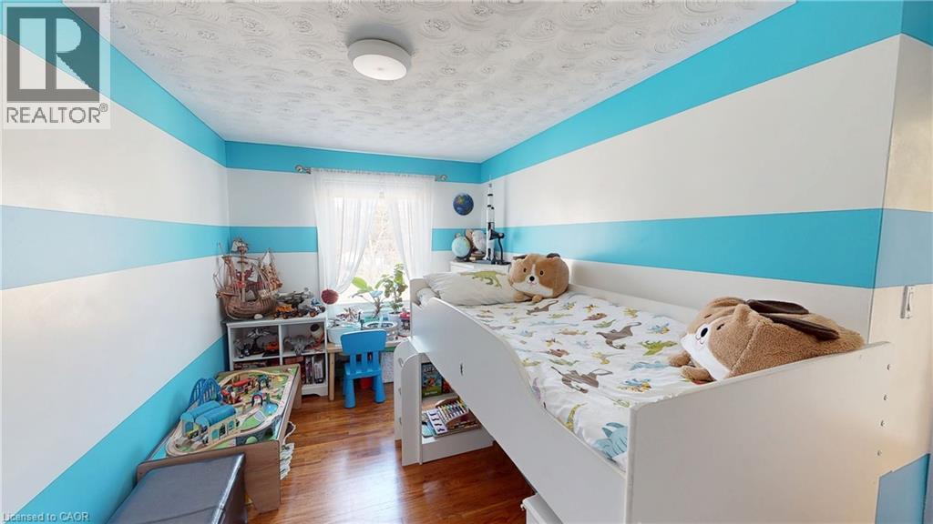 Bedroom featuring wood finished floors and a textured ceiling - 10 Armstrong Avenue, Hamilton, ON - Indoor