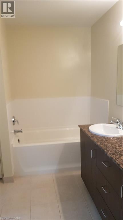 Bathroom with a bath, double vanity, and light tile patterned flooring - 191 King Street S Unit# 712, Waterloo, ON - Indoor Photo Showing Bathroom