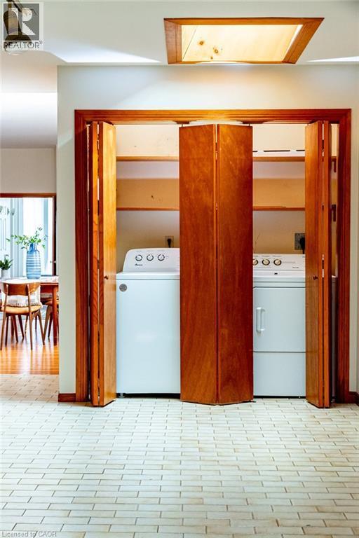 Laundry area with washing machine and clothes dryer and light floors - 218 Bay Street S, Hamilton, ON