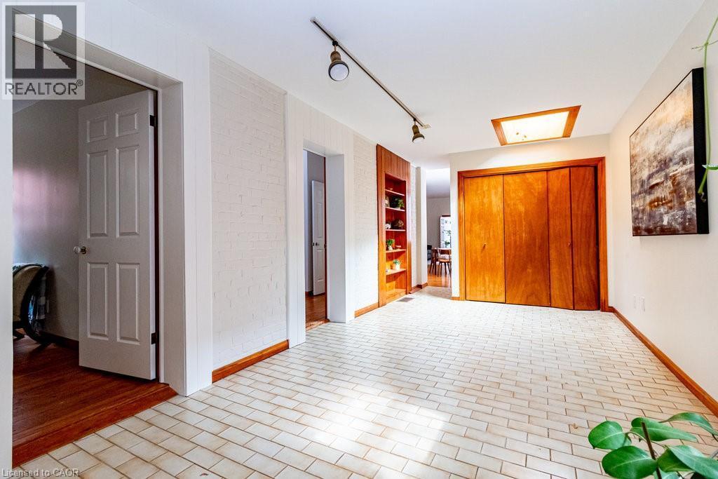 Unfurnished bedroom featuring track lighting and brick patterned floors - 218 Bay Street S, Hamilton, ON
