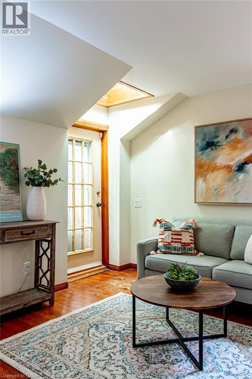 Living room with light wood-type flooring and baseboards - 218 Bay Street S, Hamilton, ON