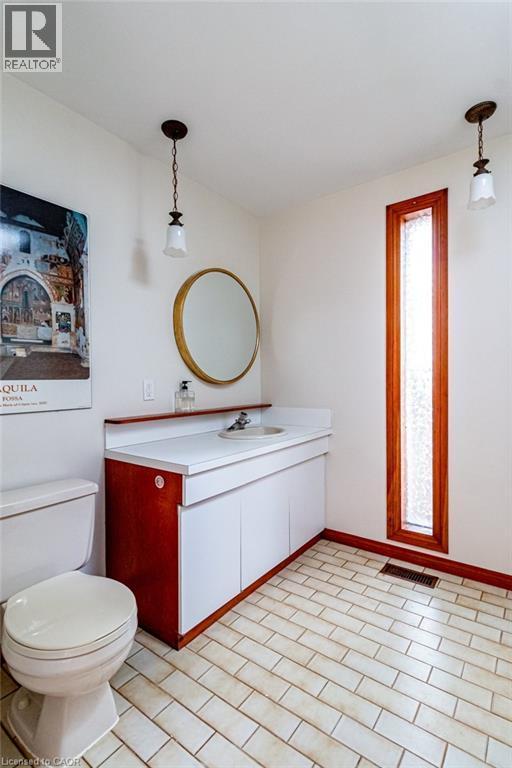 Half bathroom featuring vanity and light tile patterned flooring - 218 Bay Street S, Hamilton, ON