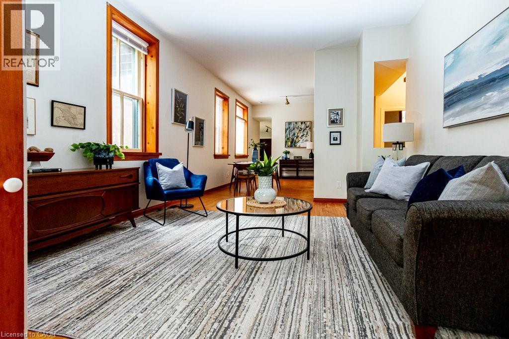 Living area with light wood-type flooring and baseboards - 218 Bay Street S, Hamilton, ON