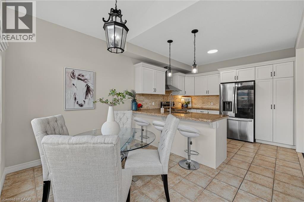 Dining space featuring light tile patterned floors and a chandelier - 100 Garinger Crescent, Binbrook, ON - Indoor Photo Showing Kitchen With Stainless Steel Kitchen With Upgraded Kitchen