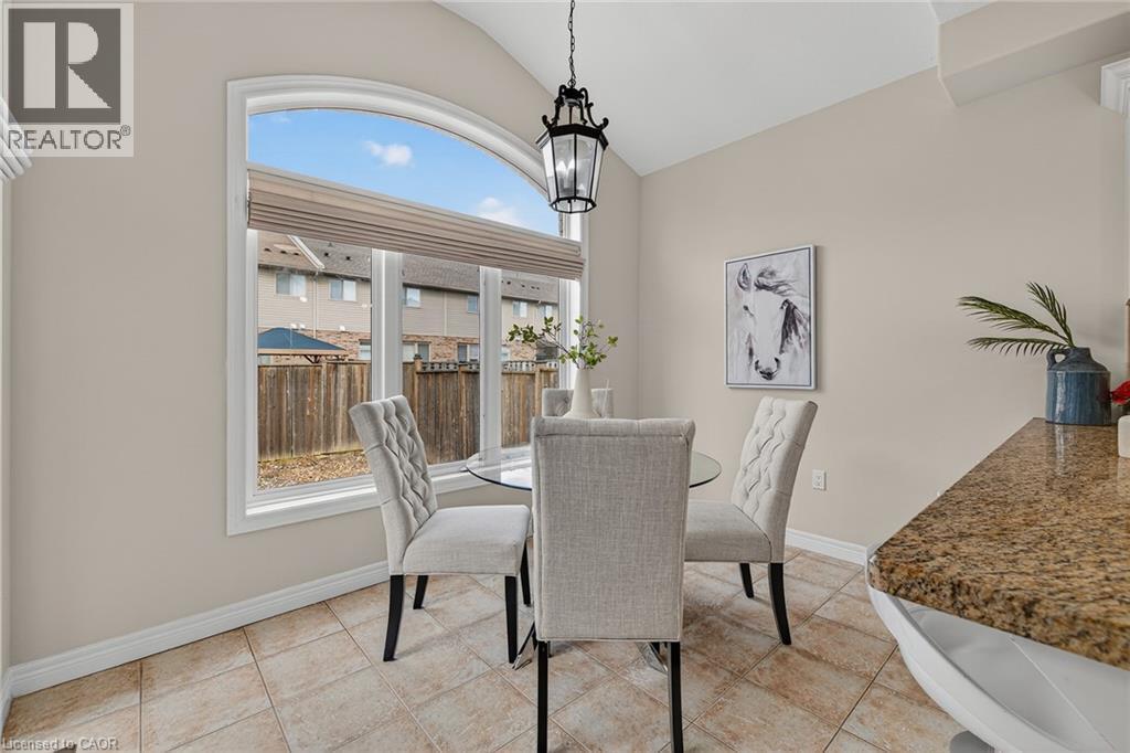 Dining room with vaulted ceiling, light tile patterned floors, and hanging lights - 100 Garinger Crescent, Binbrook, ON - Indoor Photo Showing Dining Room