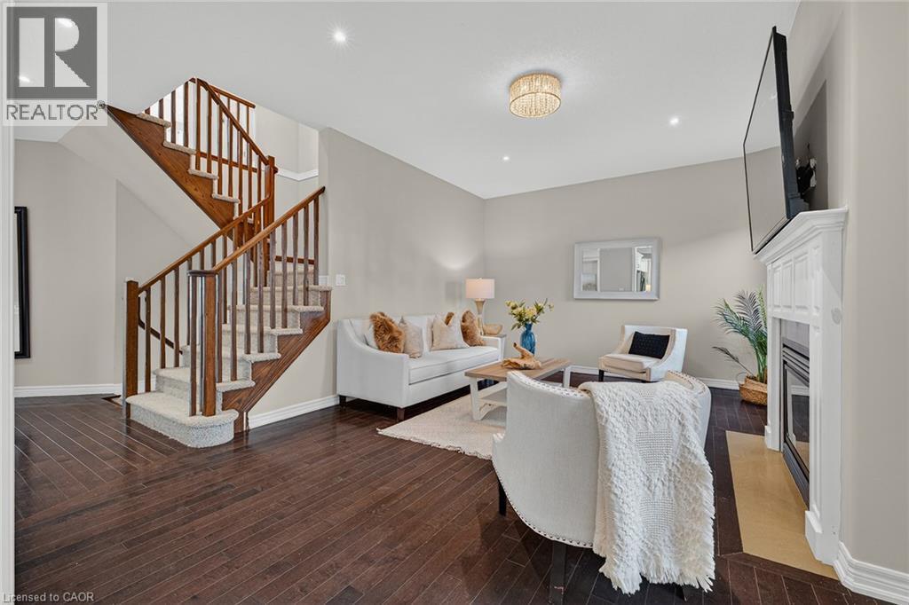 Living area featuring recessed lighting, dark wood-style flooring, and a glass covered fireplace - 100 Garinger Crescent, Binbrook, ON - Indoor Photo Showing Other Room