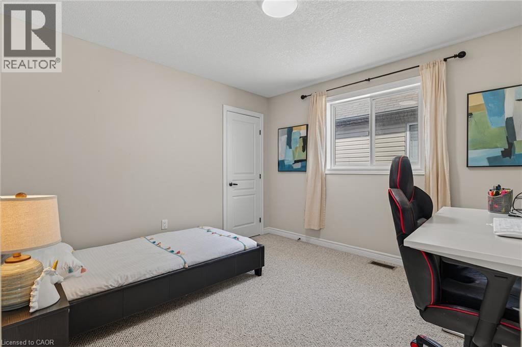 Bedroom with an office area, light colored carpet, and a textured ceiling - 100 Garinger Crescent, Binbrook, ON - Indoor