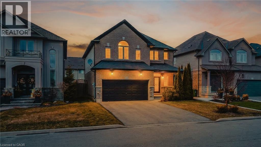 View of front facade with brick siding, driveway, an attached garage, and a yard - 100 Garinger Crescent, Binbrook, ON - Outdoor With Facade