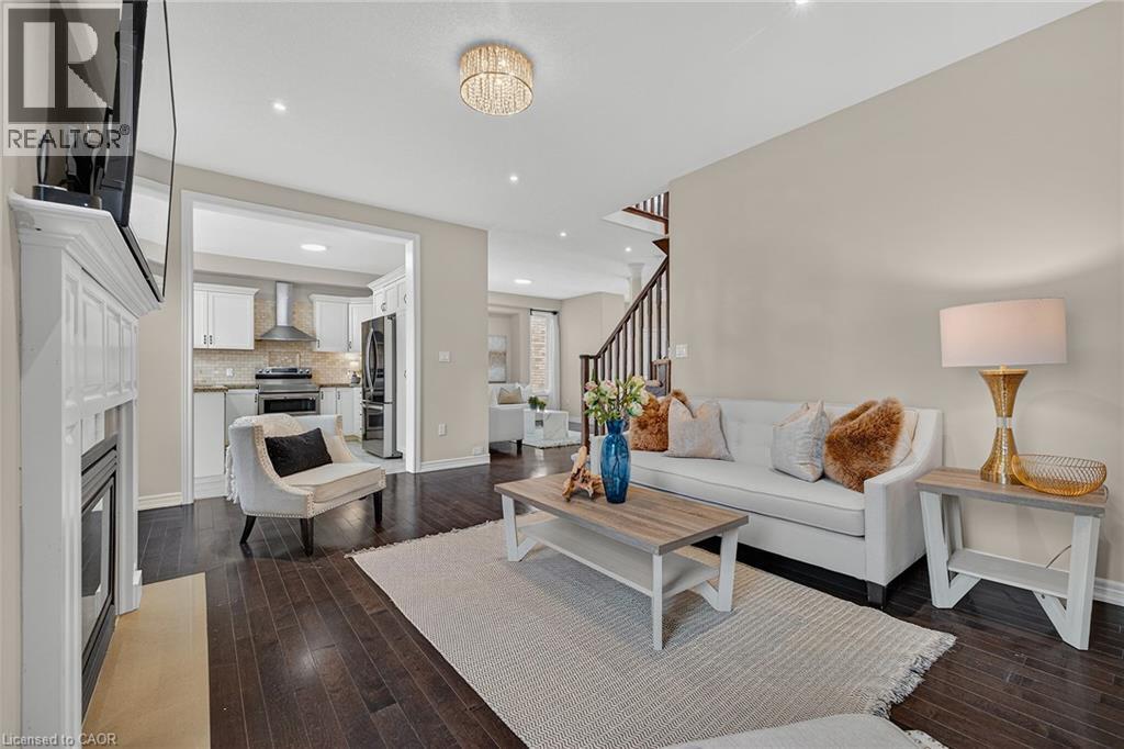 Living room featuring dark wood-type flooring, recessed lighting, and a fireplace - 100 Garinger Crescent, Binbrook, ON - Indoor Photo Showing Living Room