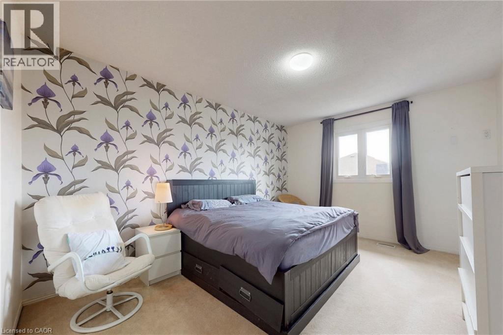 Bedroom featuring wallpapered walls, an accent wall, and light carpet - 62 Como Place, Hamilton, ON - Indoor Photo Showing Bedroom