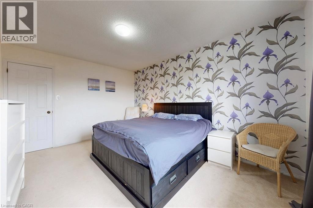 Bedroom featuring an accent wall, wallpapered walls, light colored carpet, and a textured ceiling - 62 Como Place, Hamilton, ON - Indoor Photo Showing Bedroom
