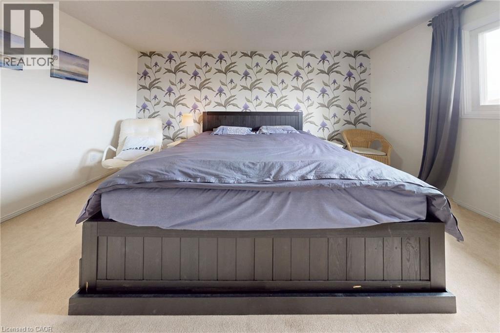 Bedroom with light colored carpet and an accent wall - 62 Como Place, Hamilton, ON - Indoor Photo Showing Bedroom