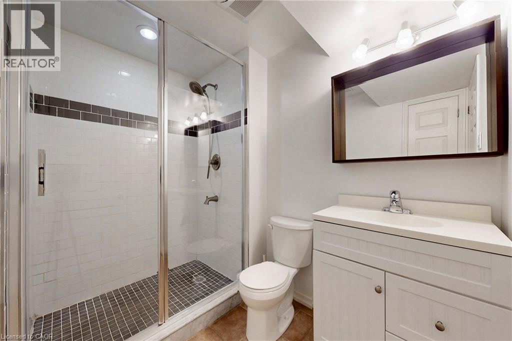 Bathroom with vanity, a shower stall, and light tile patterned floors - 62 Como Place, Hamilton, ON - Indoor Photo Showing Bathroom