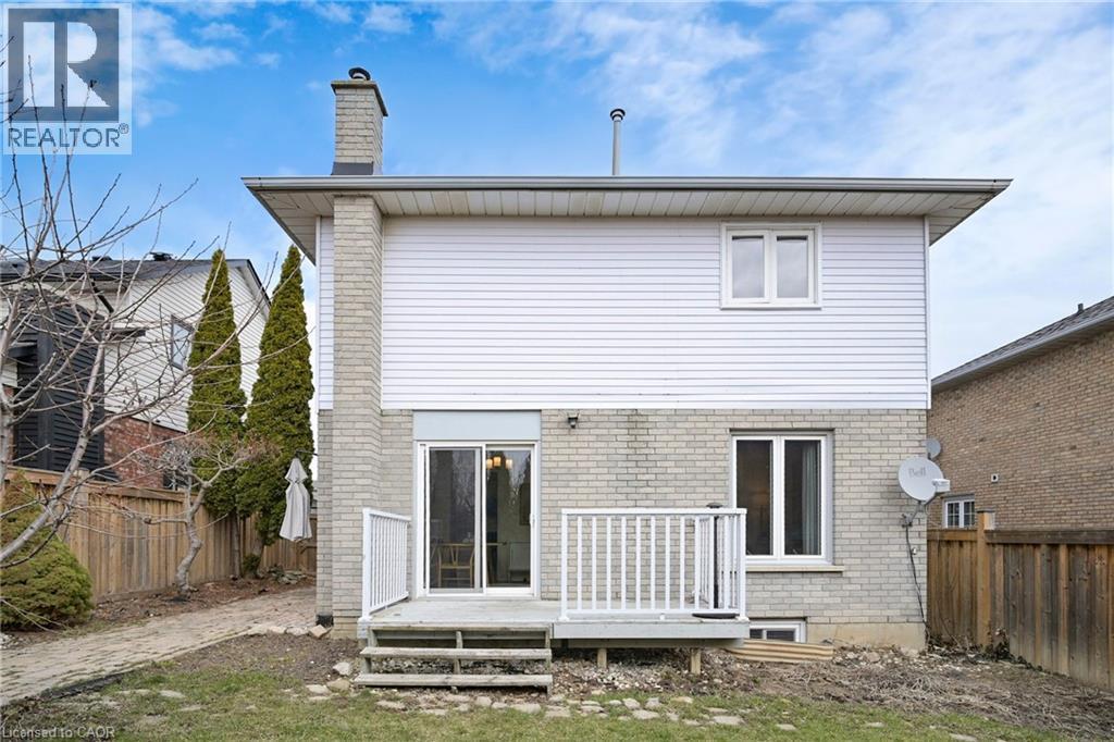 Rear view of house featuring brick siding, a fenced backyard, a wooden deck, and a chimney - 62 Como Place, Hamilton, ON - Outdoor With Exterior