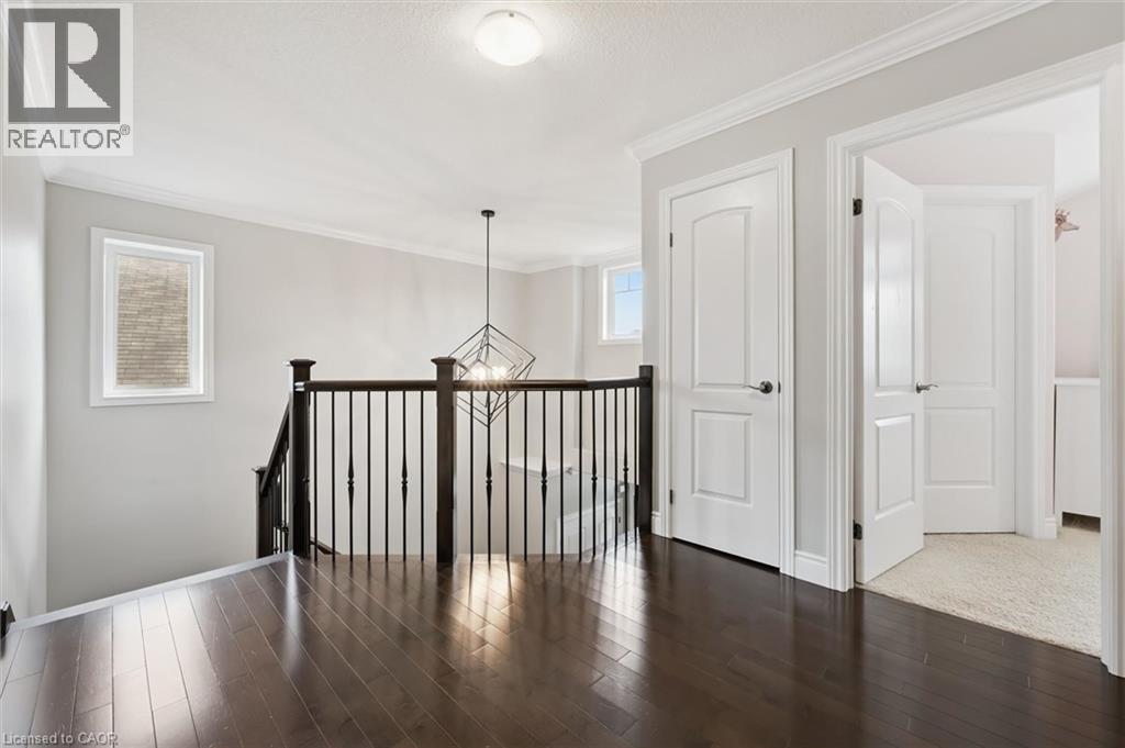 Hall with crown molding, dark wood-style flooring, an upstairs landing, and hanging lights - 469 Woodbine Avenue, Kitchener, ON - Indoor Photo Showing Other Room