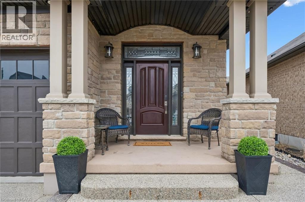 Entrance to property featuring a porch, stone siding, and a garage - 469 Woodbine Avenue, Kitchener, ON - Outdoor