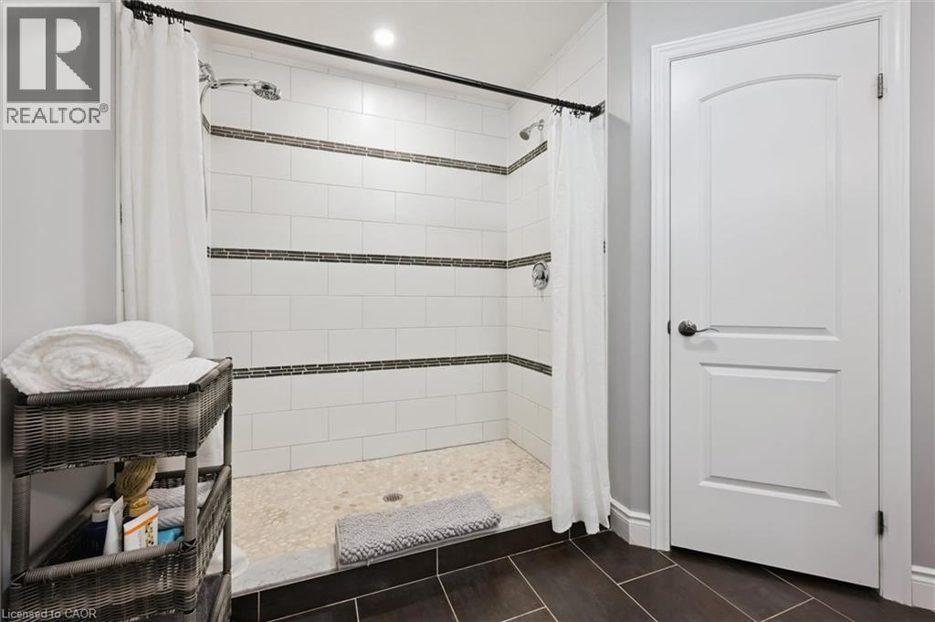 Full bath featuring a shower stall and dark tile patterned flooring - 469 Woodbine Avenue, Kitchener, ON - Indoor Photo Showing Bathroom