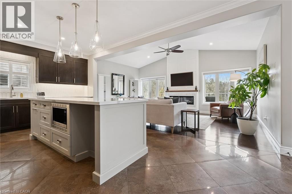 Kitchen featuring lofted ceiling, a center island, healthy amount of natural light, open floor plan, and a glass covered fireplace - 469 Woodbine Avenue, Kitchener, ON - Indoor Photo Showing Kitchen