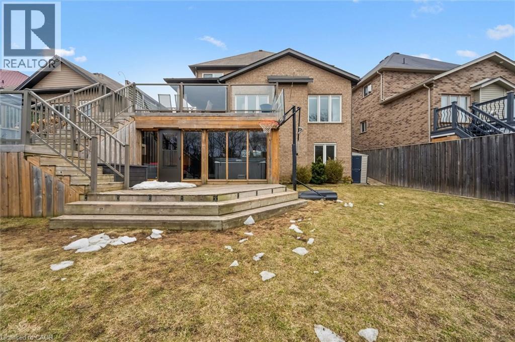 Back of property featuring a sunroom, a fenced backyard, a deck, and brick siding - 469 Woodbine Avenue, Kitchener, ON - Outdoor With Deck Patio Veranda