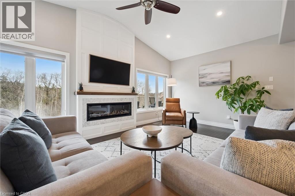 Living room with vaulted ceiling, ceiling fan, a large fireplace, wood finished floors, and recessed lighting - 469 Woodbine Avenue, Kitchener, ON - Indoor Photo Showing Living Room With Fireplace