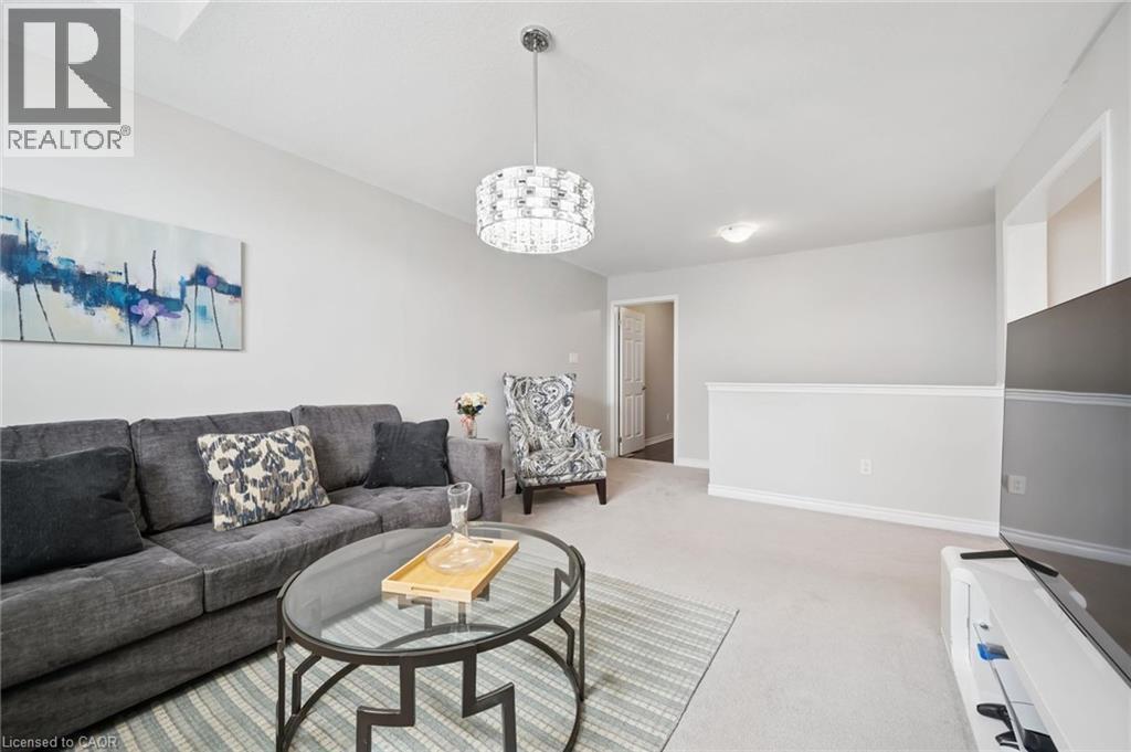 Living area with light carpet and suspended lighting - 38 Park Glen Street, Kitchener, ON - Indoor Photo Showing Living Room