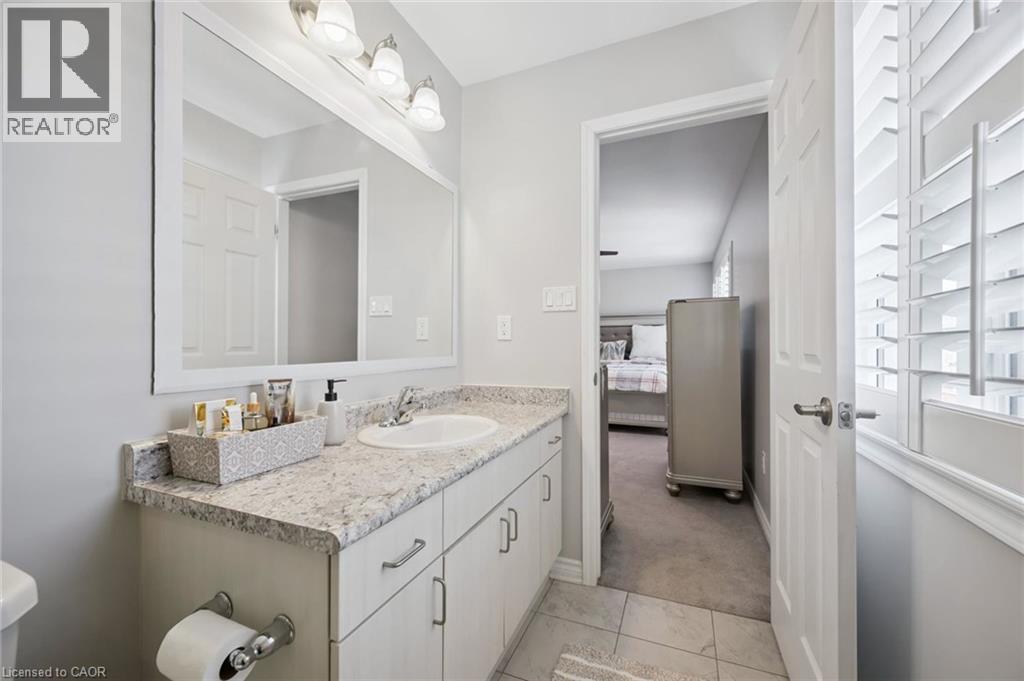 Half bath with vanity, light carpet, ensuite bathroom, and light tile patterned floors - 38 Park Glen Street, Kitchener, ON - Indoor Photo Showing Bathroom