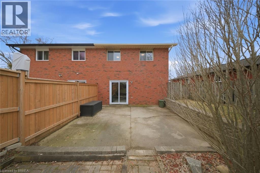 Rear view of house featuring a fenced backyard, a patio area, and brick siding - 7 Forest Drive, Paris, ON - Outdoor With Exterior