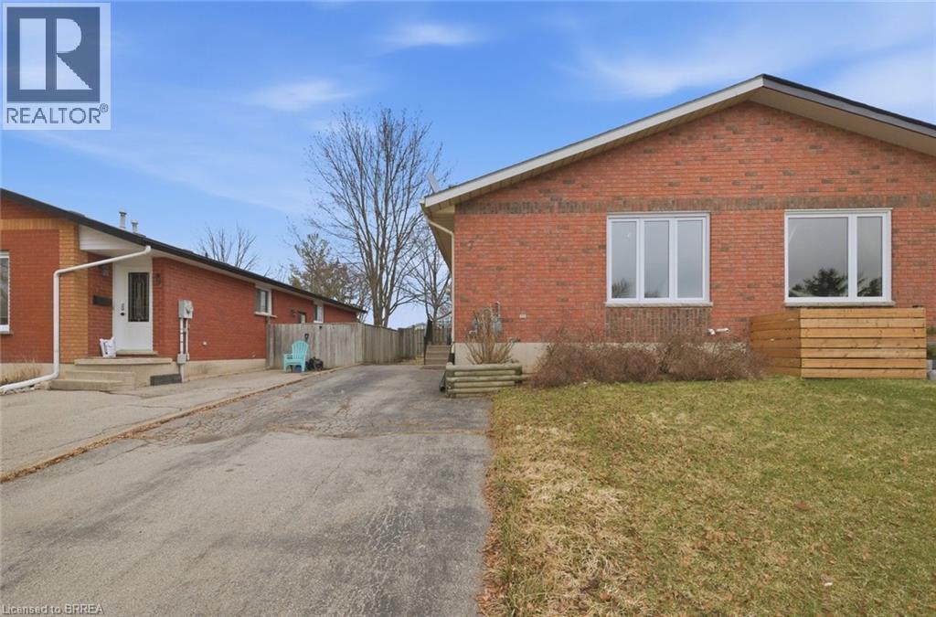 View of property exterior with a yard, brick siding, entry steps, and driveway - 7 Forest Drive, Paris, ON - Outdoor With Exterior