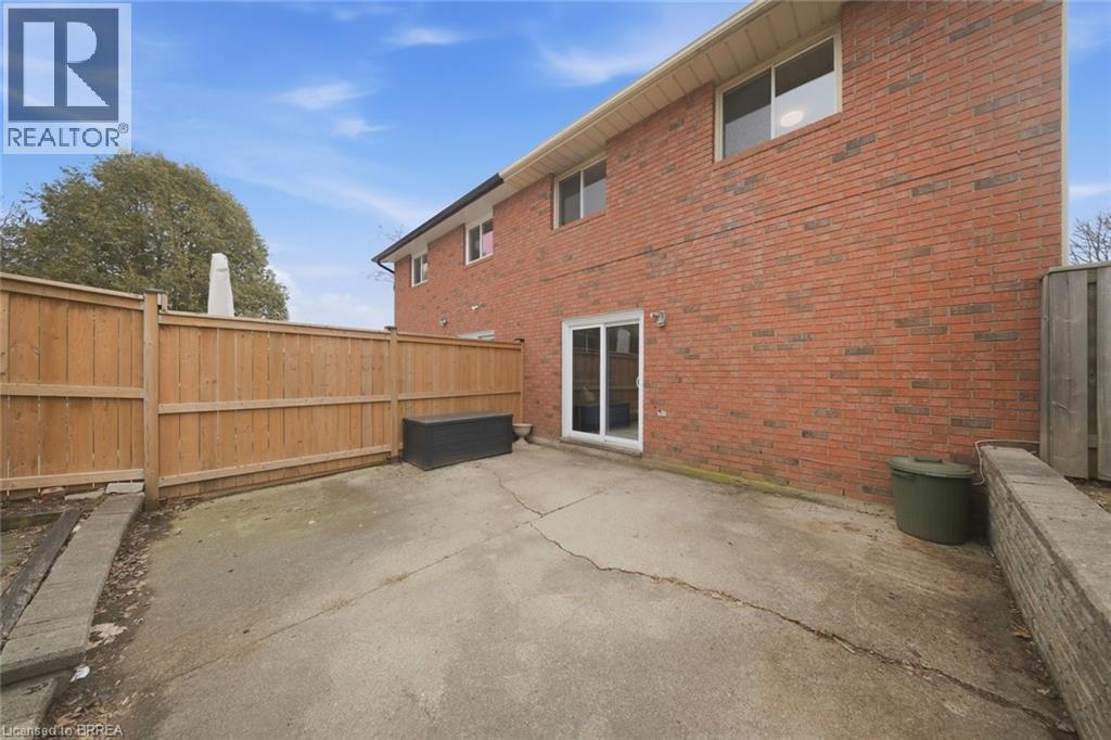 Back of property featuring a fenced backyard, brick siding, and a patio area - 7 Forest Drive, Paris, ON - Outdoor With Exterior