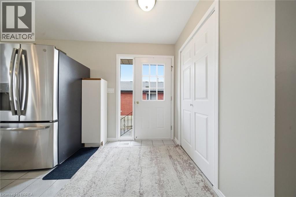 Kitchen featuring stainless steel fridge with ice dispenser and light tile patterned floors - 7 Forest Drive, Paris, ON - Indoor Photo Showing Other Room