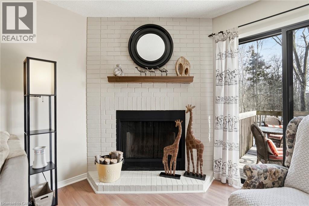 Living room featuring a fireplace and light wood-type flooring - 18 Webster Way, Georgetown, ON - Indoor Photo Showing Living Room With Fireplace