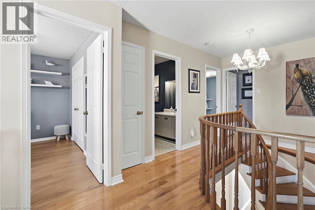 Corridor featuring an upstairs landing, a textured ceiling, light wood-style flooring, and a chandelier - 18 Webster Way, Georgetown, ON - Indoor Photo Showing Other Room