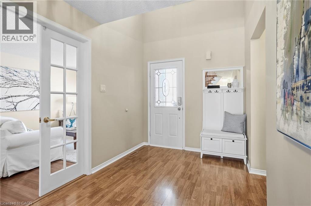 Entryway with light wood-style floors, a textured ceiling, and french doors - 18 Webster Way, Georgetown, ON - Indoor Photo Showing Other Room