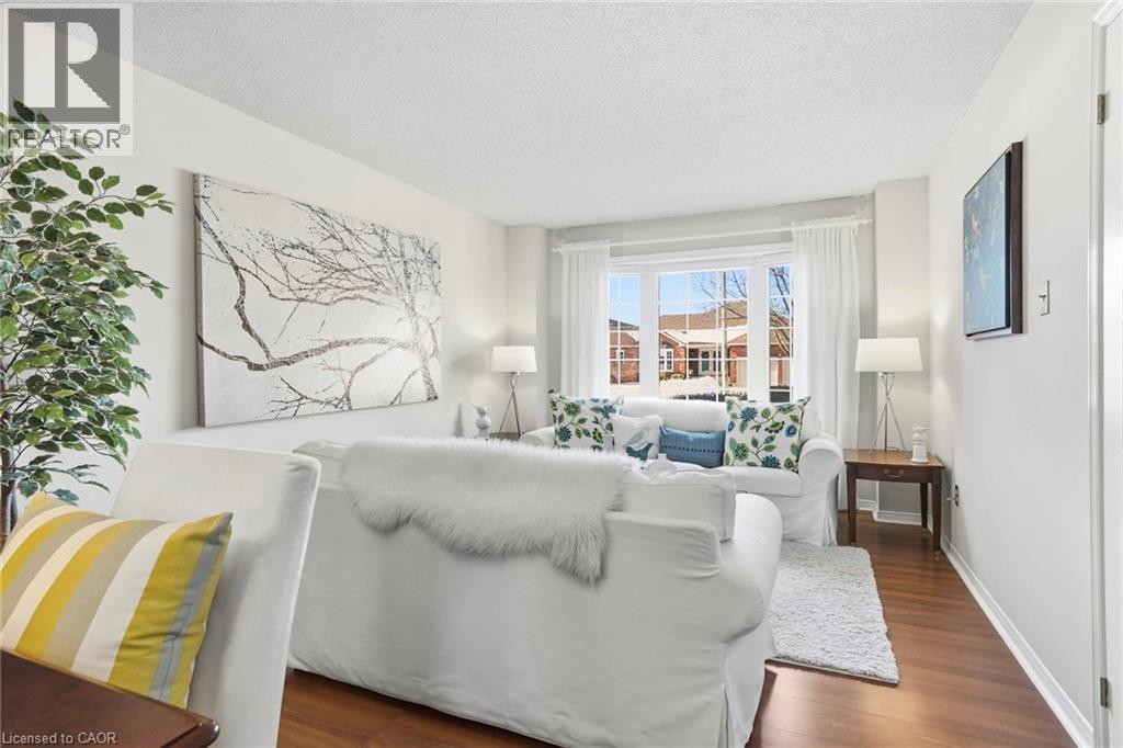 Living room featuring a textured ceiling and dark wood-style flooring - 18 Webster Way, Georgetown, ON - Indoor Photo Showing Living Room