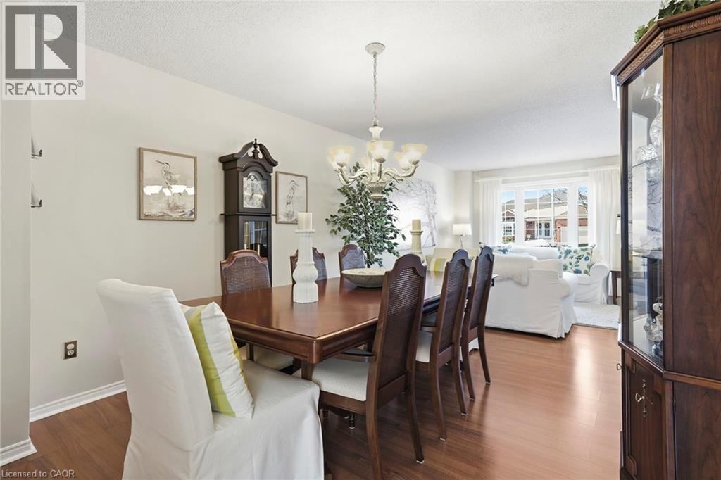 Dining room featuring dark wood finished floors, suspended lighting, and a textured ceiling - 18 Webster Way, Georgetown, ON - Indoor Photo Showing Dining Room