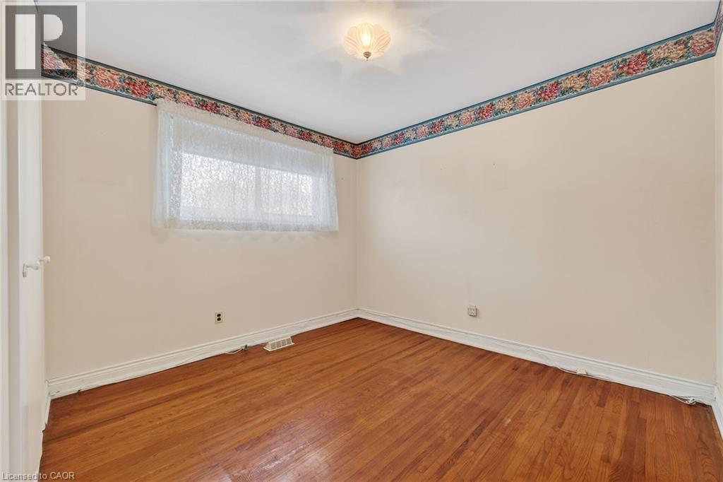 Unfurnished room with baseboards and wood-type flooring - 21 Bluebird Avenue, Hamilton, ON - Indoor Photo Showing Other Room